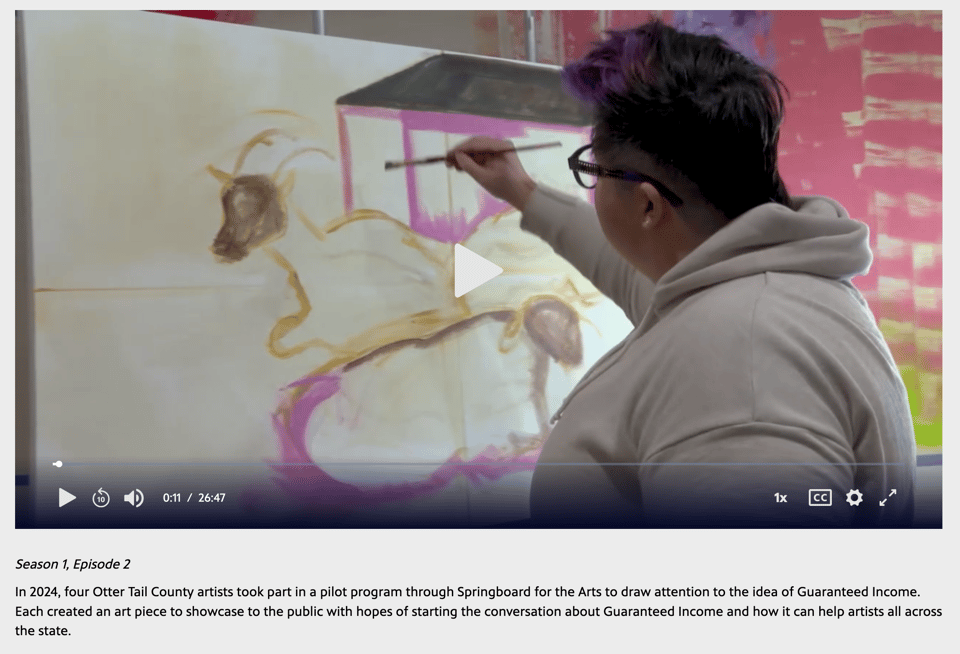 Artist Kandace painting a large canvas with three goat outlines