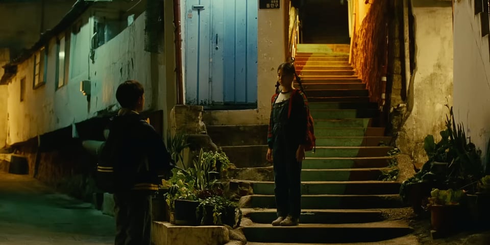 12-year-old Hae-Sung says bye to 12-year-old Nora at night in Seoul.