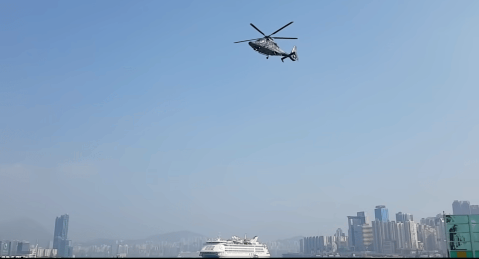 A helicopter floats eerily above a city scape.