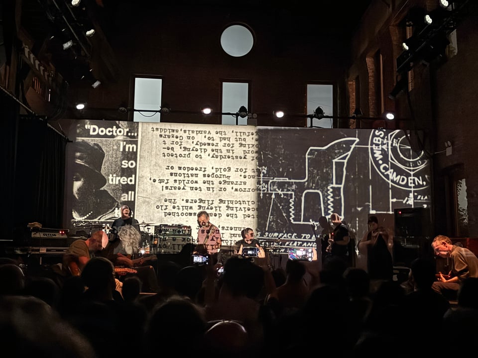 the band Godspeed You! Black Emperor performs in front of multiple projections
