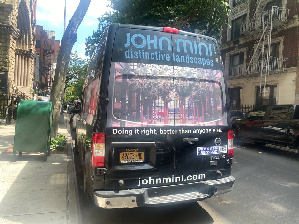 A truck for John Mini Distinctive Landscapes, which is shrink-wrapped with an all around photograph of Brookfield Place / the World Financial Center.