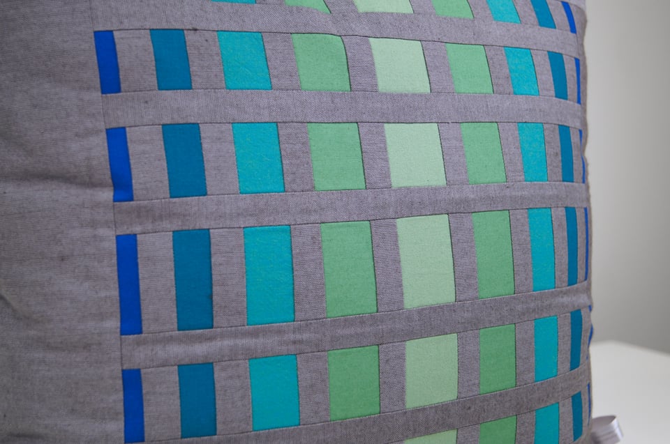 hand-crafted pillow in greens, blues, and gray