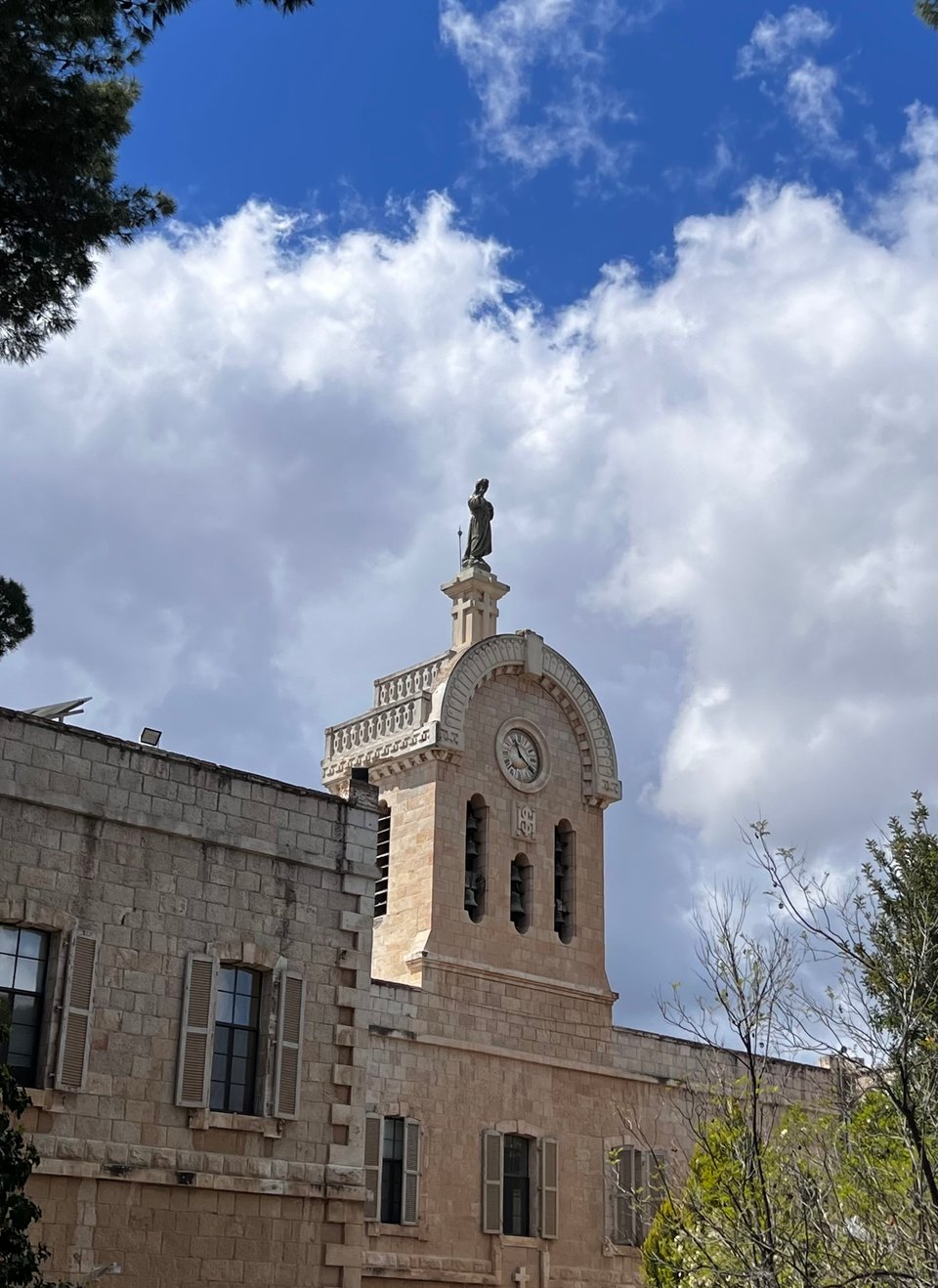 A building made of Jerusalem stone with a statue atop an arched steeple