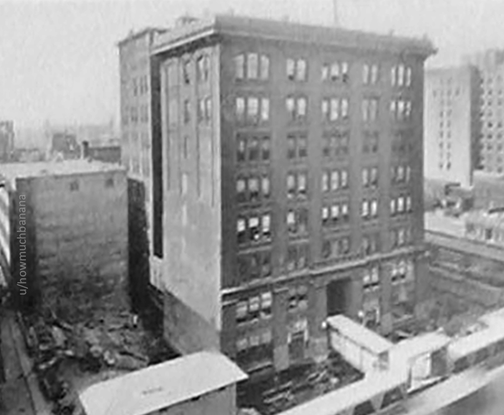 An animated black-and-white gif of a old early-20th century building being rotated 90 degrees