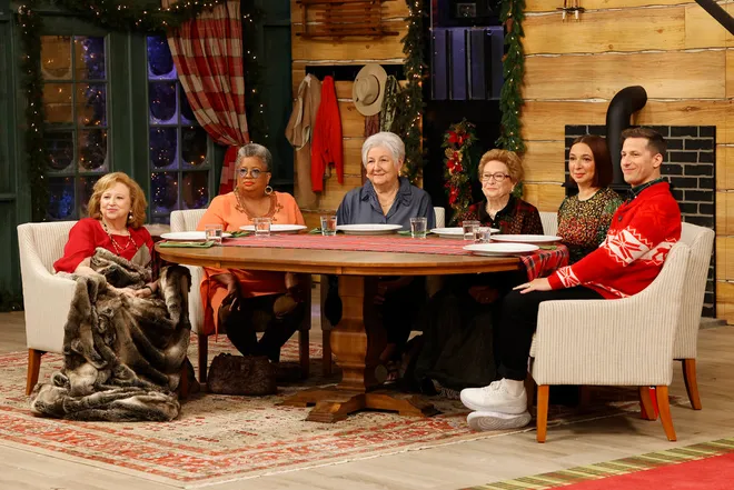 a group of older women people sitting around a table with two younger people