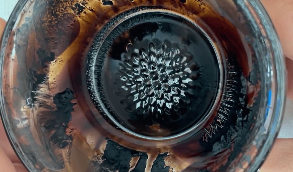a screenshot from a video showing a black liquid that's formed into spikes