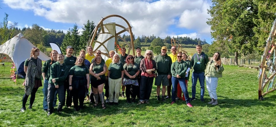 A large group of community mappers and other Public Map staff pose for a photograph in the meadow where Lle Llais was held
