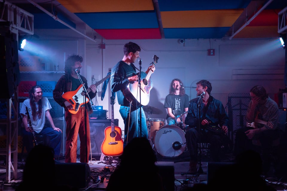 lots of musicians on stage for Travess, caught in a moment of laughter