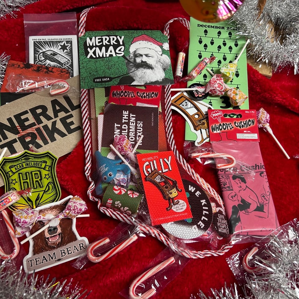 A cheap mess xmas stocking filled with zines, stickers, pins, candy, cheap toys, and assorted other stuff