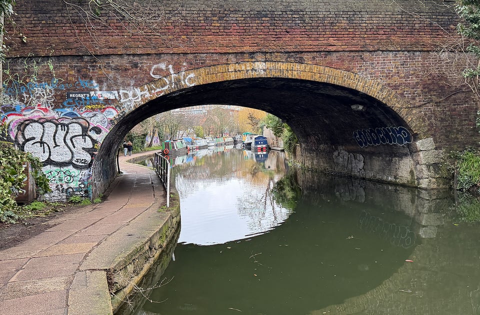 A bridge over the canal in Camden is partially covered in graffiti.