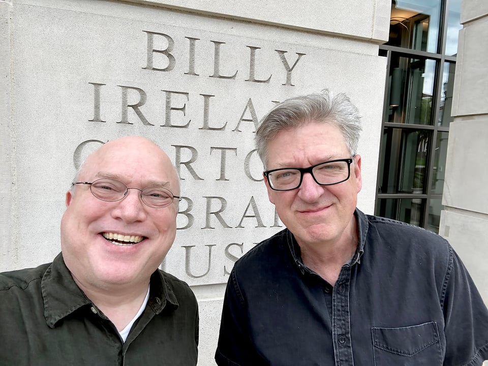 Photo of Glenn Fleishman and Derf Backderf standing in front of a sign reading Billy Ireland Cartoon Library and Museum