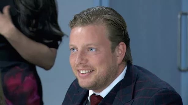 A picture of a white man in his mid-twenties. He is wearing a suit and tie, has a big build and is smiling. Some may recognise him as Thomas Skinner, who appeared on the Apprentice some years ago.