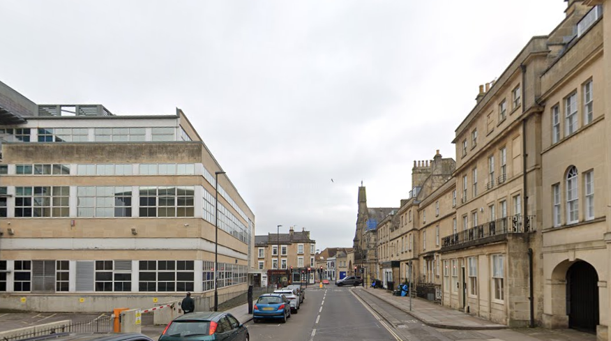 A 1960s office block across the road from some Georgian terraces. Both are dressed in Bath stone, and have the same roof line.
