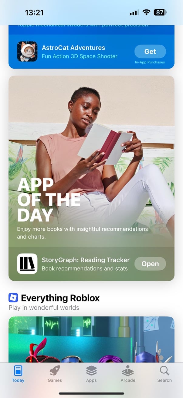 Screenshot of the App Store featuring StoryGraph: Reading Tracker as App of the Day. A person sits outdoors reading a book, with the caption: “Enjoy more books with insightful recommendations and charts.” The StoryGraph app card appears below with an “Open” button.