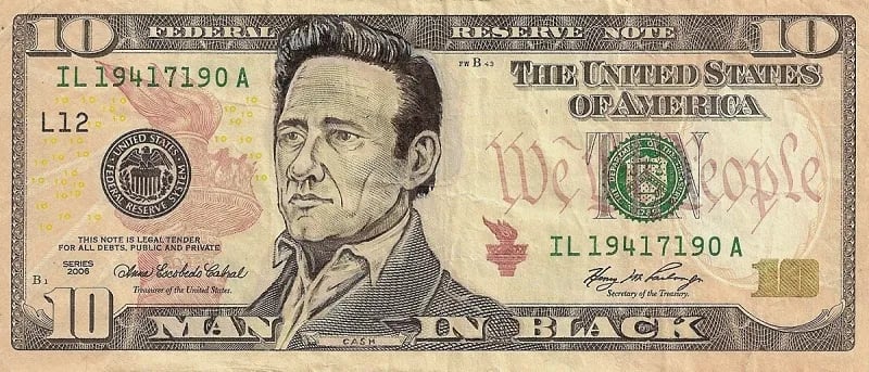 A US ten-dollar bill that has been altered by artist James Charles so that the portrait is of Johnny Cash and the text beneath him reads "MAN IN BLACK." 