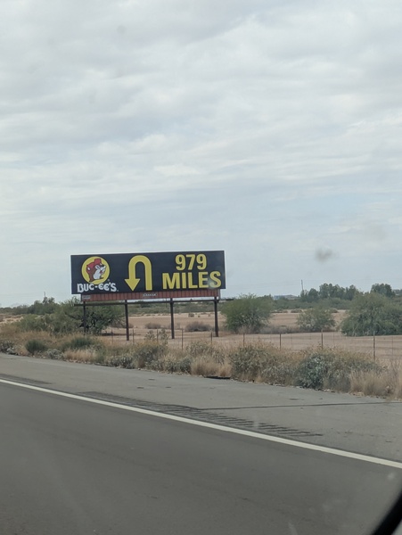 A Buc-ee's billboard with a U-turn signal and text that reads, "979 MILES"