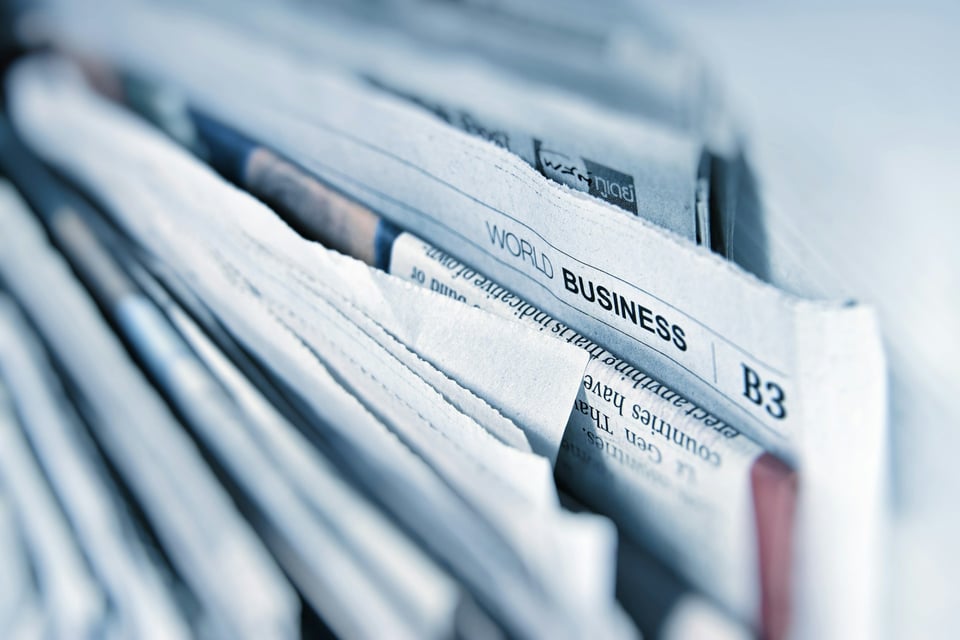 A close-up of newspapers. The one visible section name reads "World Business | B3." Photo by AbsolutVision on Unsplash