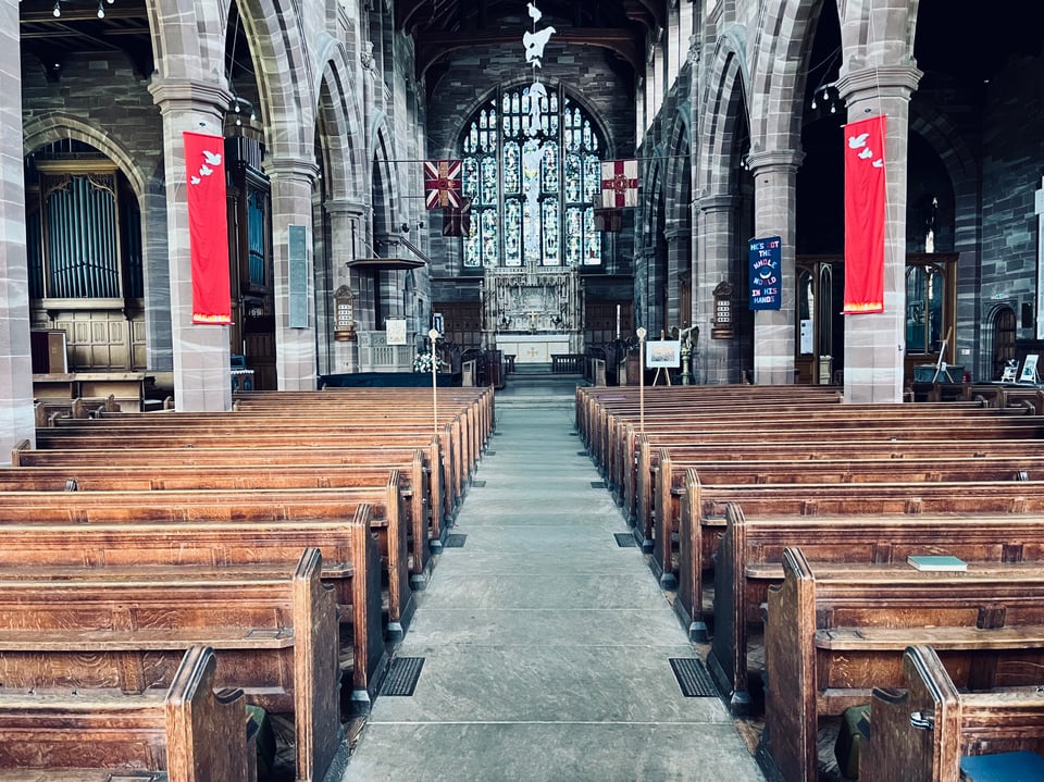 The empty interior of a church with wooden benches and thick stone walls, nice and cool!