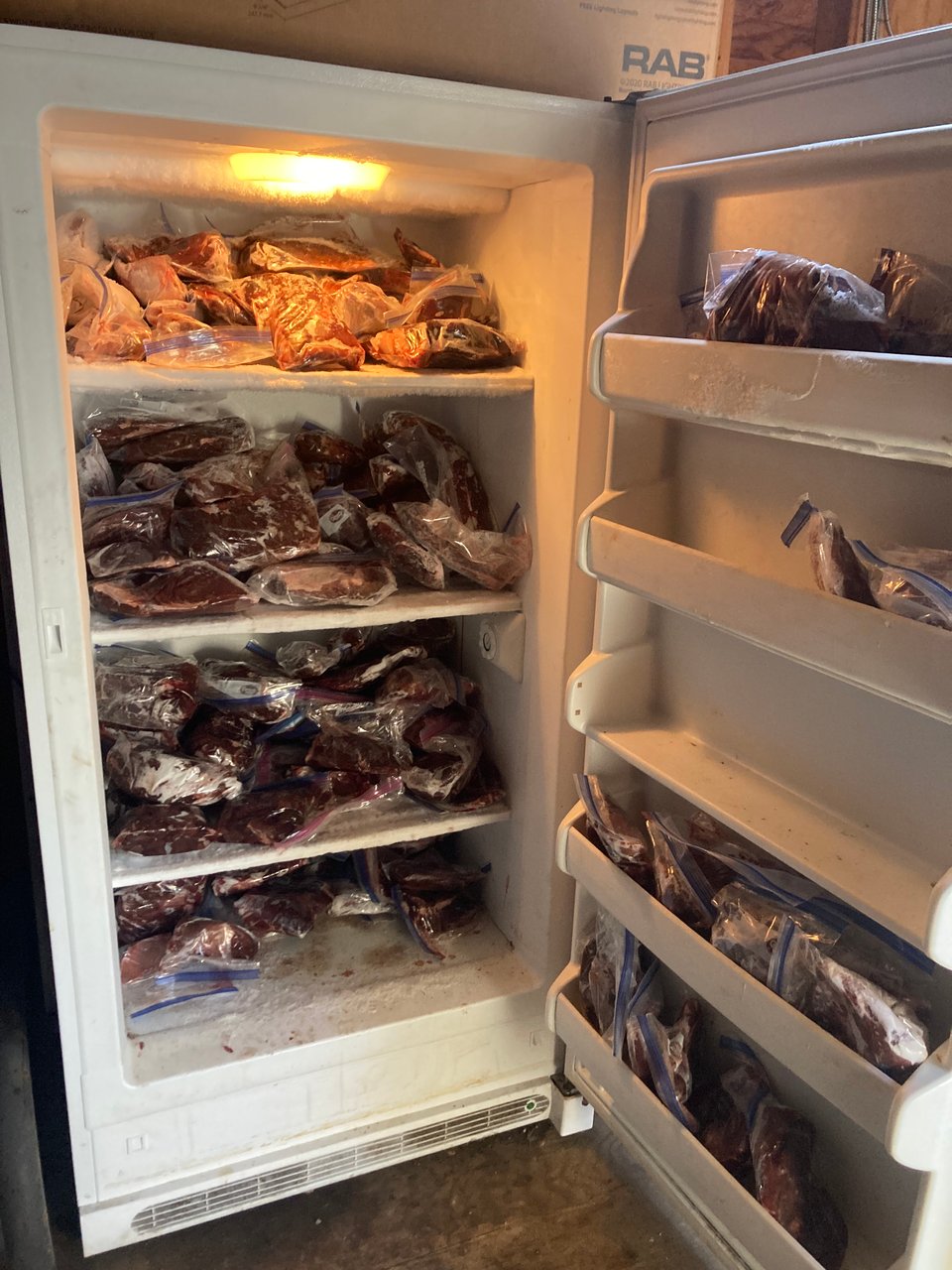open fridge stuffed full of plastic wrapped chunks of venison