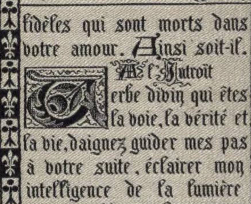 A closeup of the page. You can see tha the white areas are woven, and the black text is also. The text has jagged edges that indicate it is woven from small pixels. The text is in French and is adorned with a large A in a drop cap