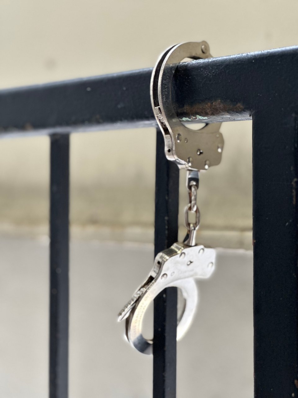 photo of handcuffs locked around the railing of stairs in a parking garage