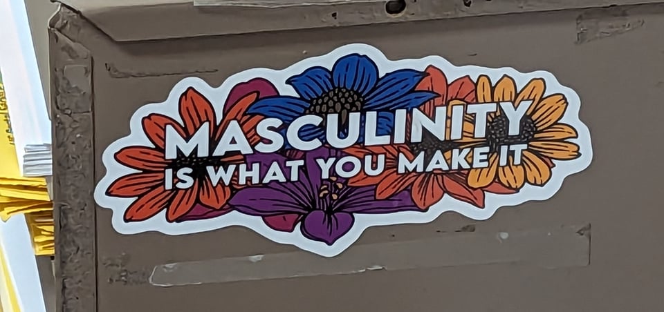 I love this sticker that is on display at P.O. Plus in the Castro, which reads "MASCULINITY IS WHAT YOU MAKE IT," with a background of flowers in different colors