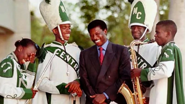 Foutanga Babani Sissoko, in a very nice suit, shares a laugh with members of the Miami Central High School marching band.