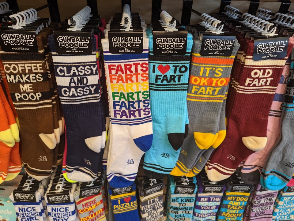 A row of socks that say things like FARTS and CLASSY AND GASSY and OLD FART