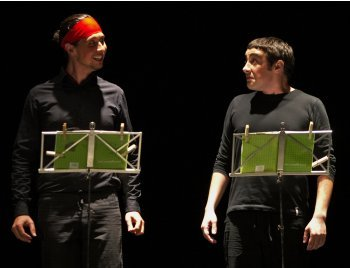 Two actors wearing black interacting with each other on a scene