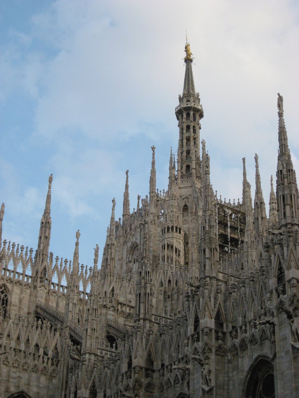 photo of portion of Il Duomo in Milan, against a pale blue sky