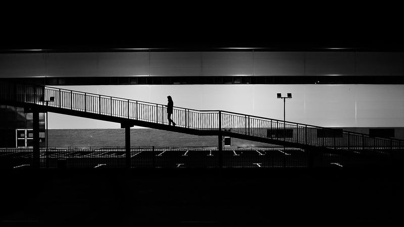 Person climbing a stairway, in silhouette