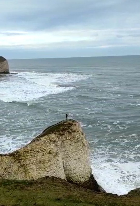 Bianca on a narrow cliff edge, jutting out over the sea