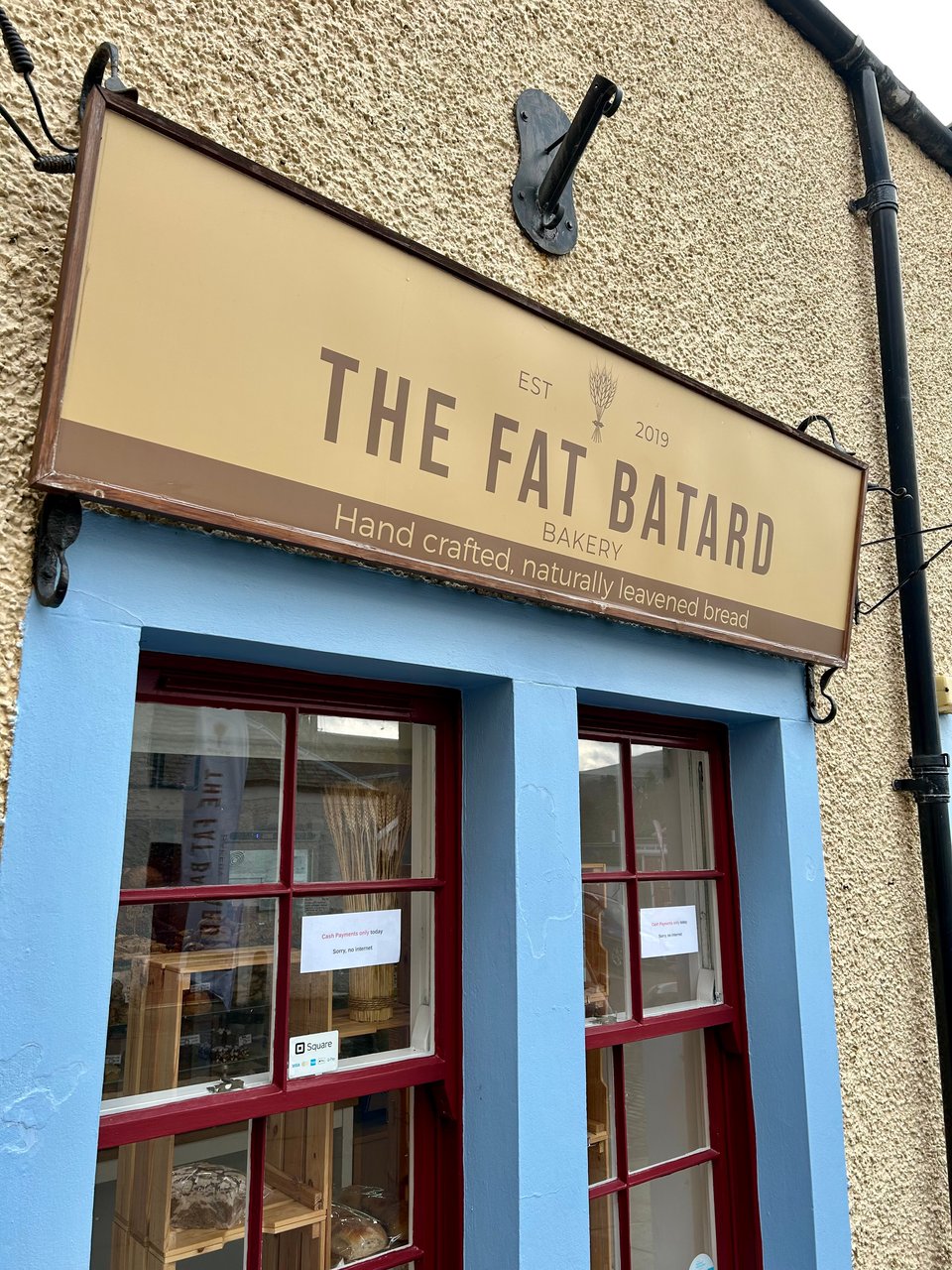 The window and sign of the Fat Batard Bakery in Peebles in pale blue and cream. Image by Rowan Ambrose.