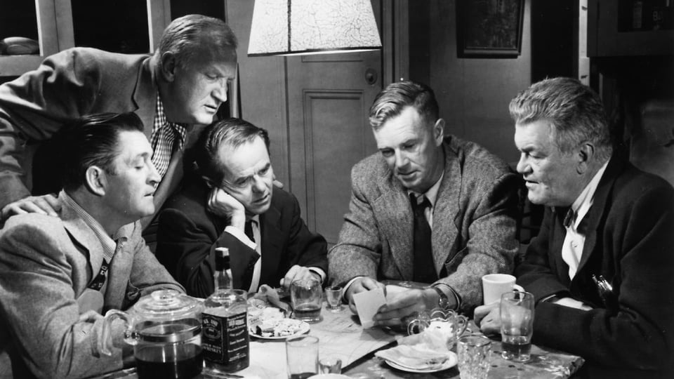 The main protagonists of the movie sitting at a table, planning the heist.