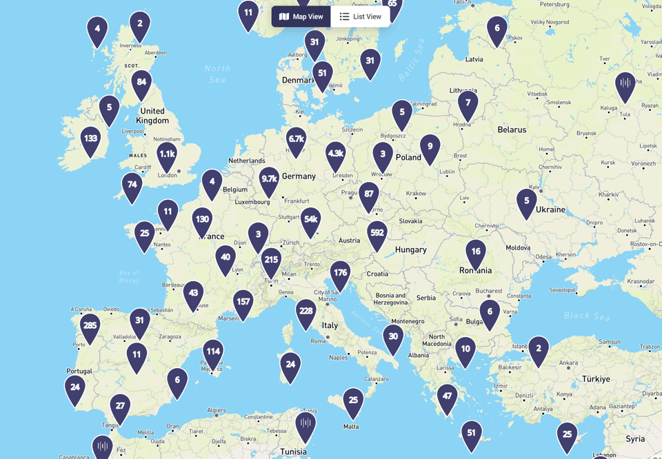 A digital map of Europe is shown with dark blue location markers displaying white numbers, indicating quantities at various points across the continent. The highest concentrations appear in Germany (9.7k), France (130), Italy (228), and the United Kingdom (84), with smaller clusters in surrounding countries. The map offers both “Map View” and “List View” options, suggesting an interactive interface for exploring regional data or listings.