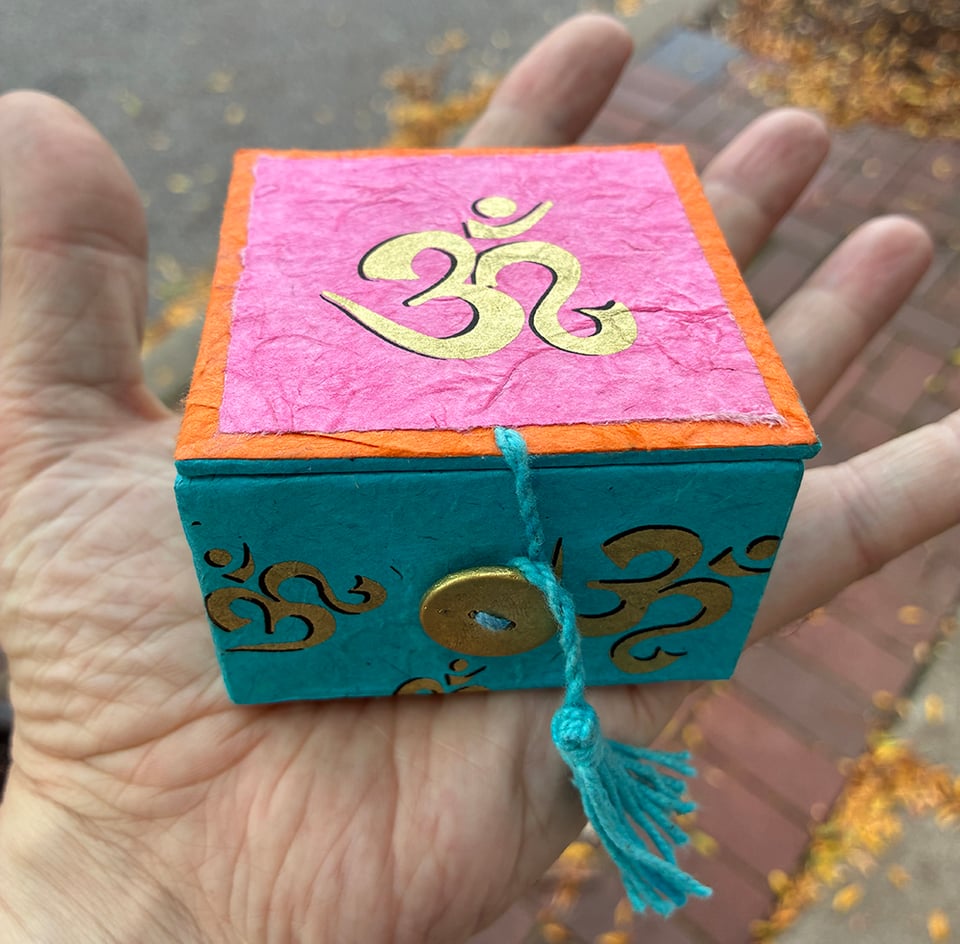 My hand, holding a small pink and blue box. What's in the box? It's a mystery.