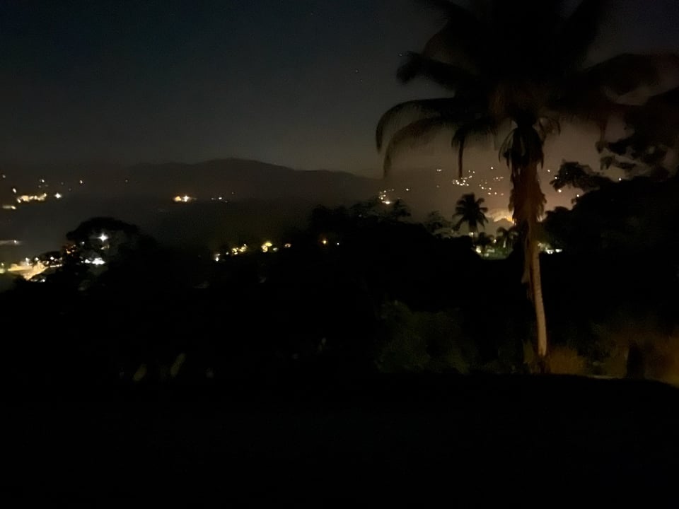 Nighttime photo of a Puerto Rican landscape with lights glowing in various populated places