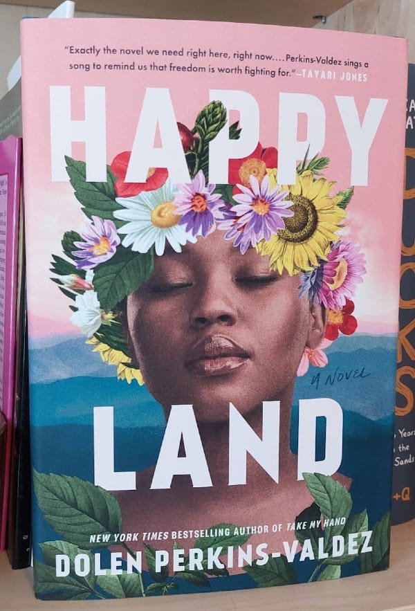 Black woman with flowers in her hair and a backdrop of the blue Appalachian mountains