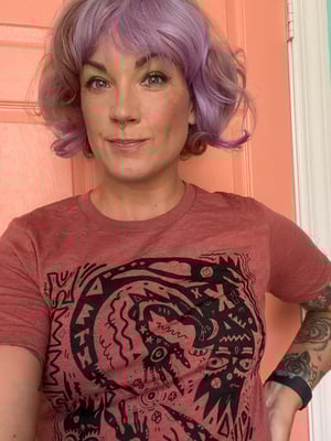 Lucianne smirking a little after they dyed their hair a dramatically-different shade of blonde and lavender