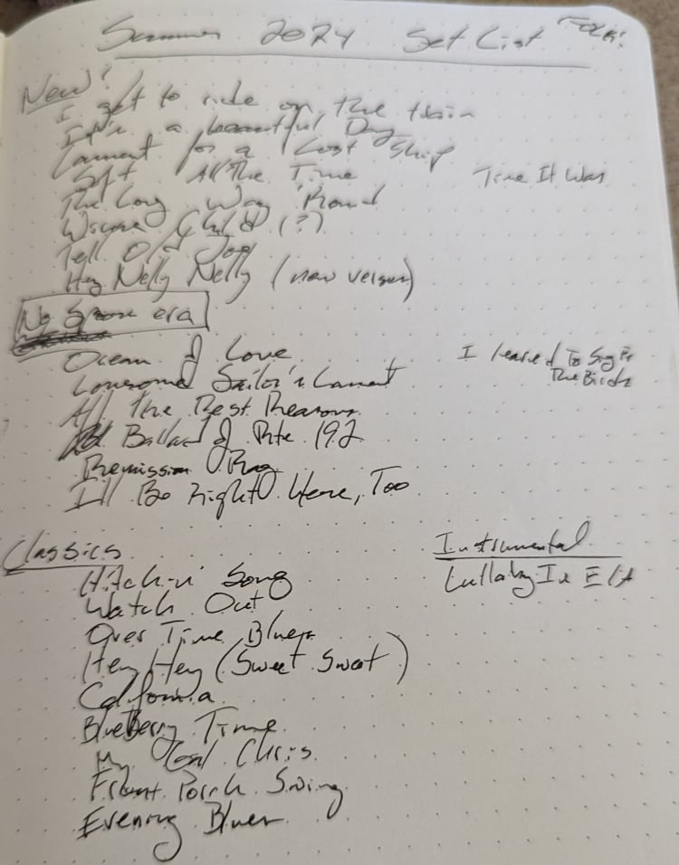 A long list of songs, scrawled in flowing ink on fancy notebook paper. Divided into "new", "No Spoons Era", "classics", and "instrumental"