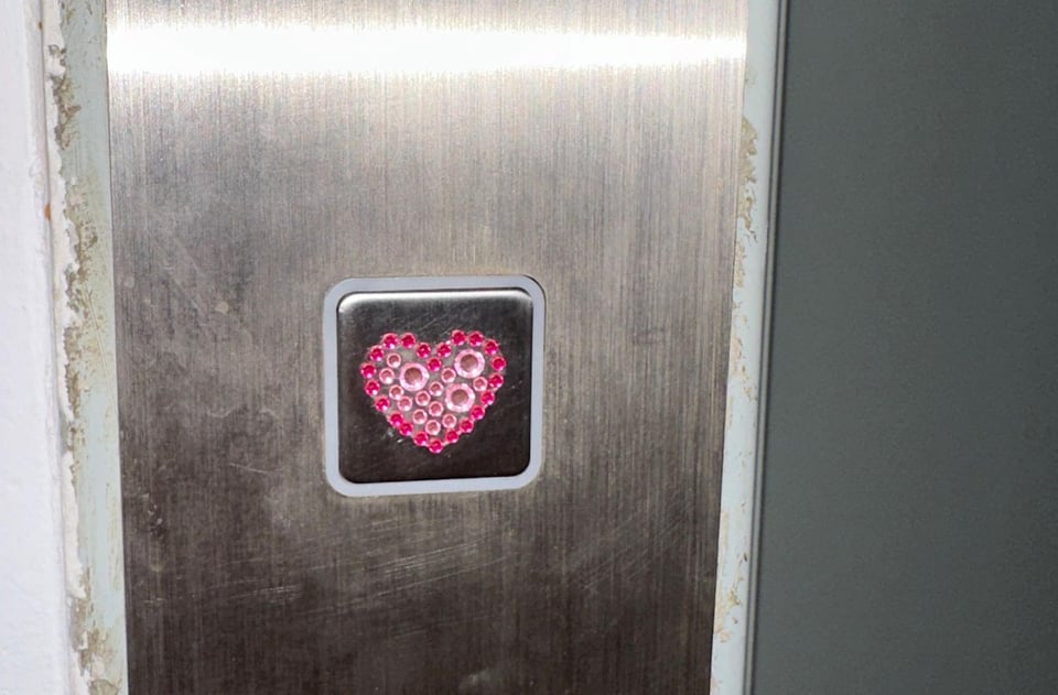 A button bedazzled with a pink heart.