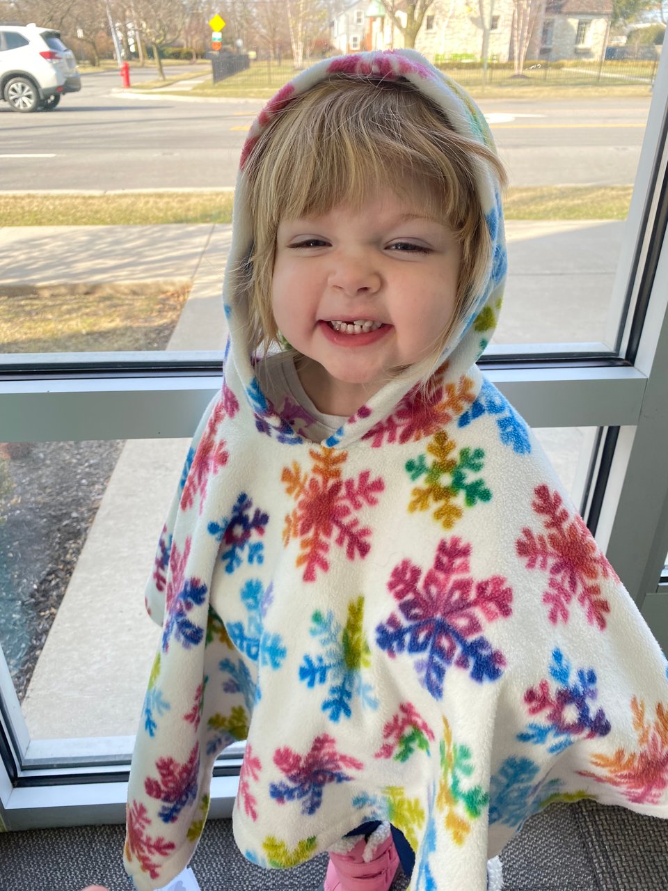 a little girl wearing a snowflake poncho