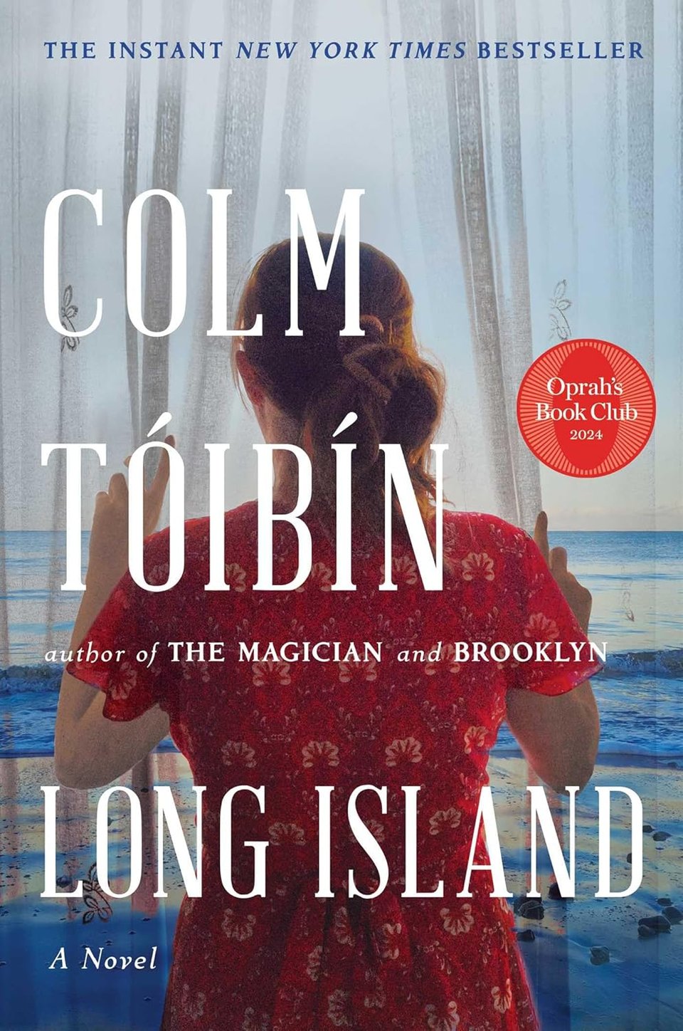 A woman in a patterend red dress and a ponytail from the back, looking out at a blue ocean and parting gauzy curtains. Large serif white lettering: