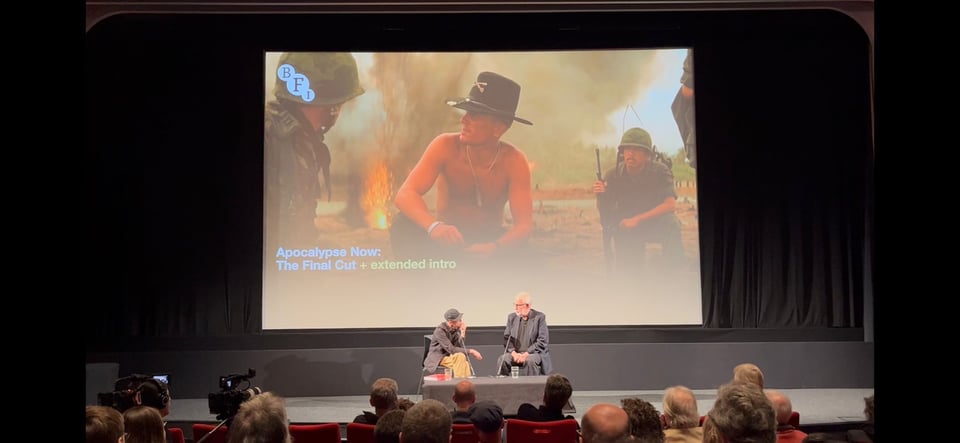 The stage at the BFI with Walter Murch and the moderator engaged in a conversation, while a still from Apocalypse Now is shown on the screen. There are audience members looking on.