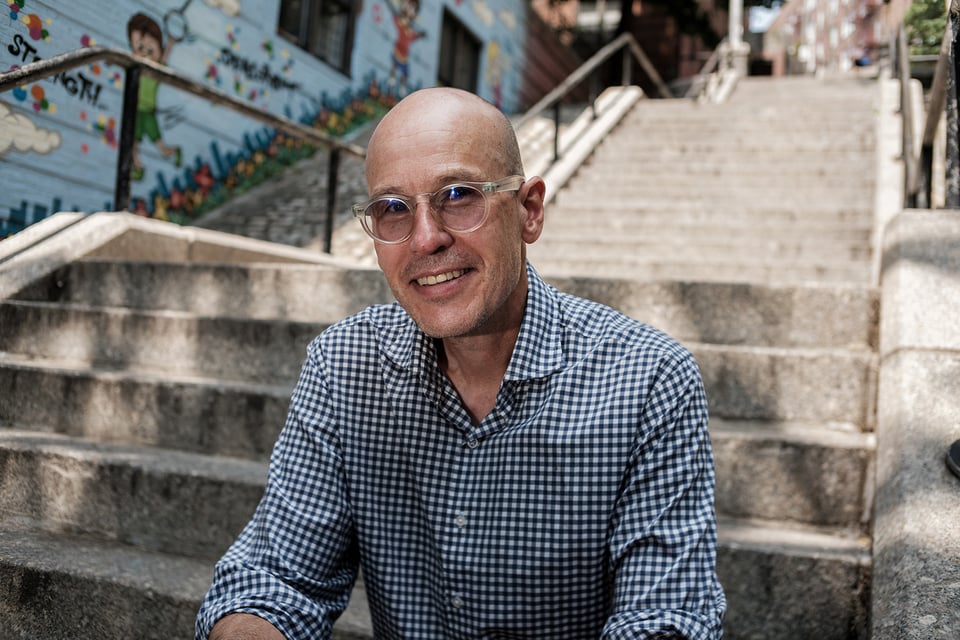 Writer Ben Ratliff seated on an outdoor staircase.
