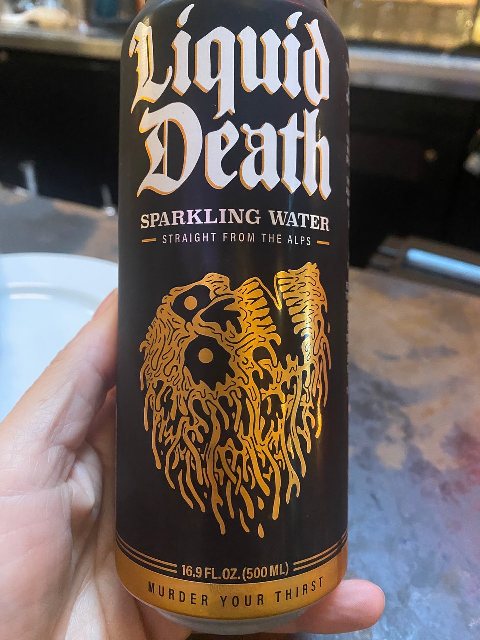 A hand holding a can of something called Liquid Death, that is just sparkling water