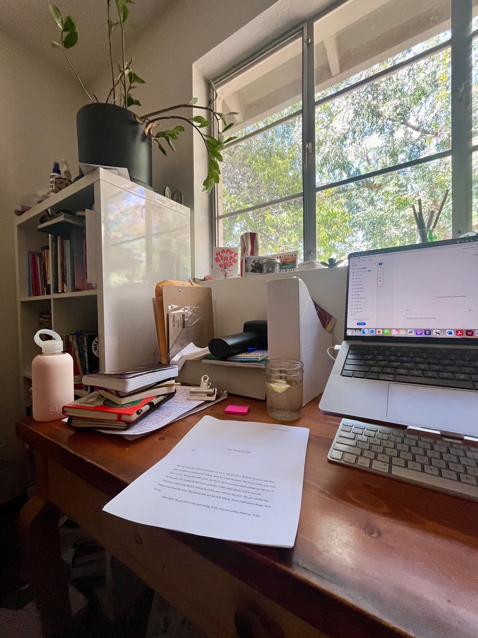 My desk with laptop, papers, notebooks, water bottle and more