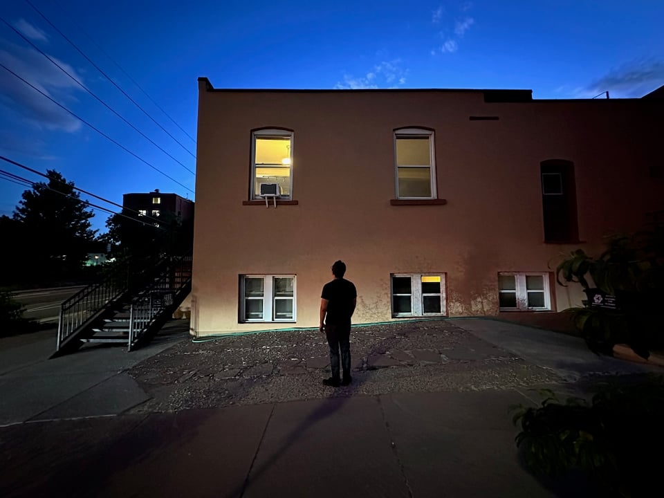 Norton looking up at a window evaluating the position of the AC bracket