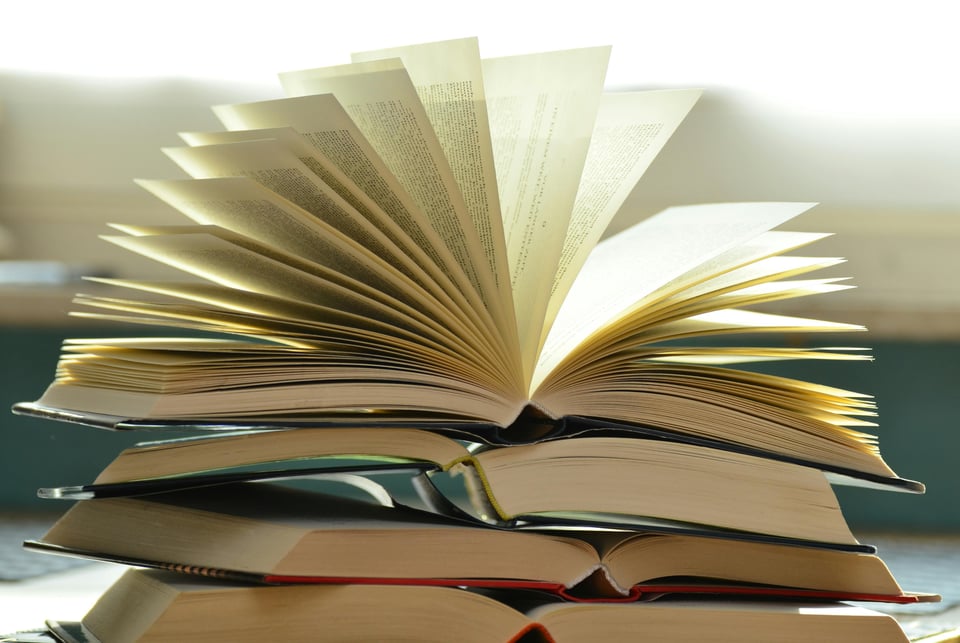 Stock photo of a stack of open books piled on top of each other.