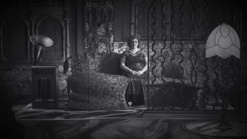 a woman in an ornate dress sits listening to music.